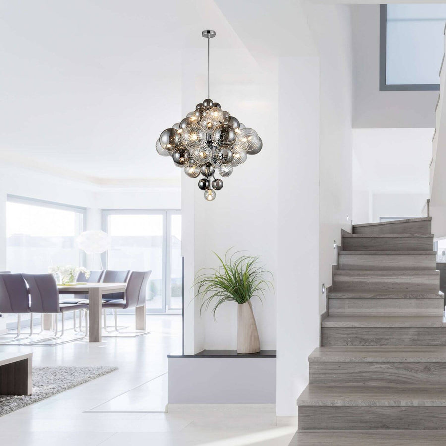 Luminaire suspendu allumé au-dessus d'un escalier et d'une salle à manger lumineuse
