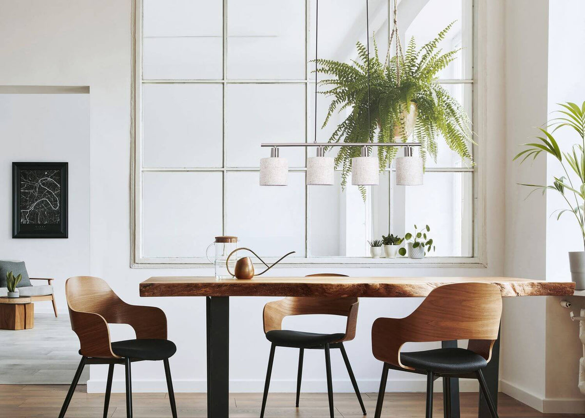 Luminaire suspendu au-dessus d'un comptoir en bois massif, dans une cuisine claire et végétalisée.