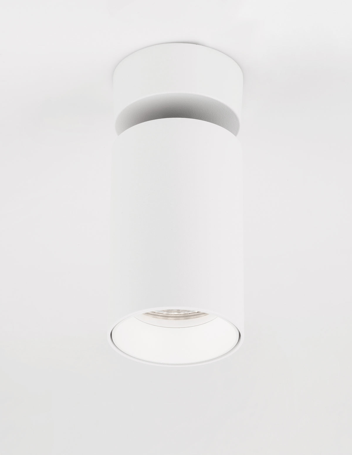 Vue de dessous du plafonnier blanc orienté vers le bas, forme cylindrique
