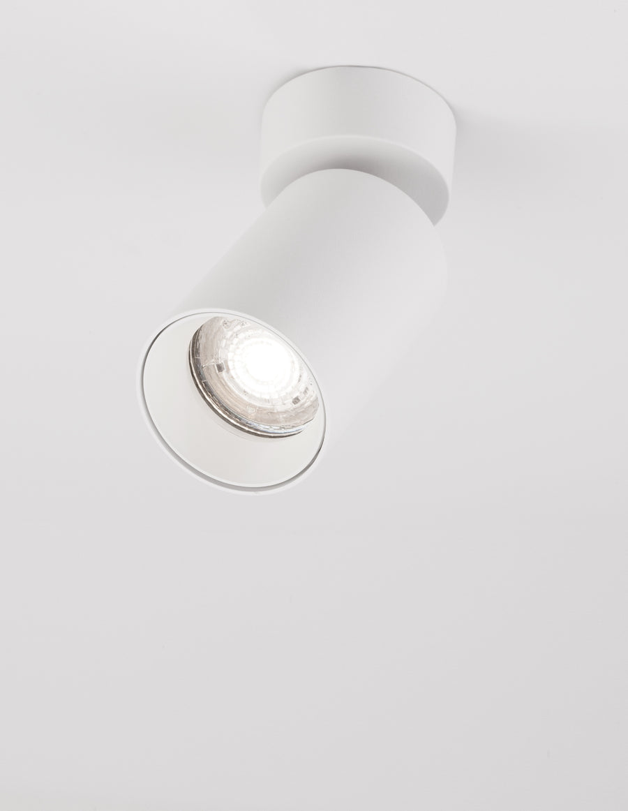 Spot blanc incliné sur fond blanc avec sa lentille LED allumée