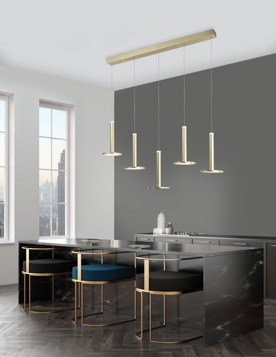 Suspension cinq pendants cylindriques dorés au-dessus d'un îlot de cuisine sombre