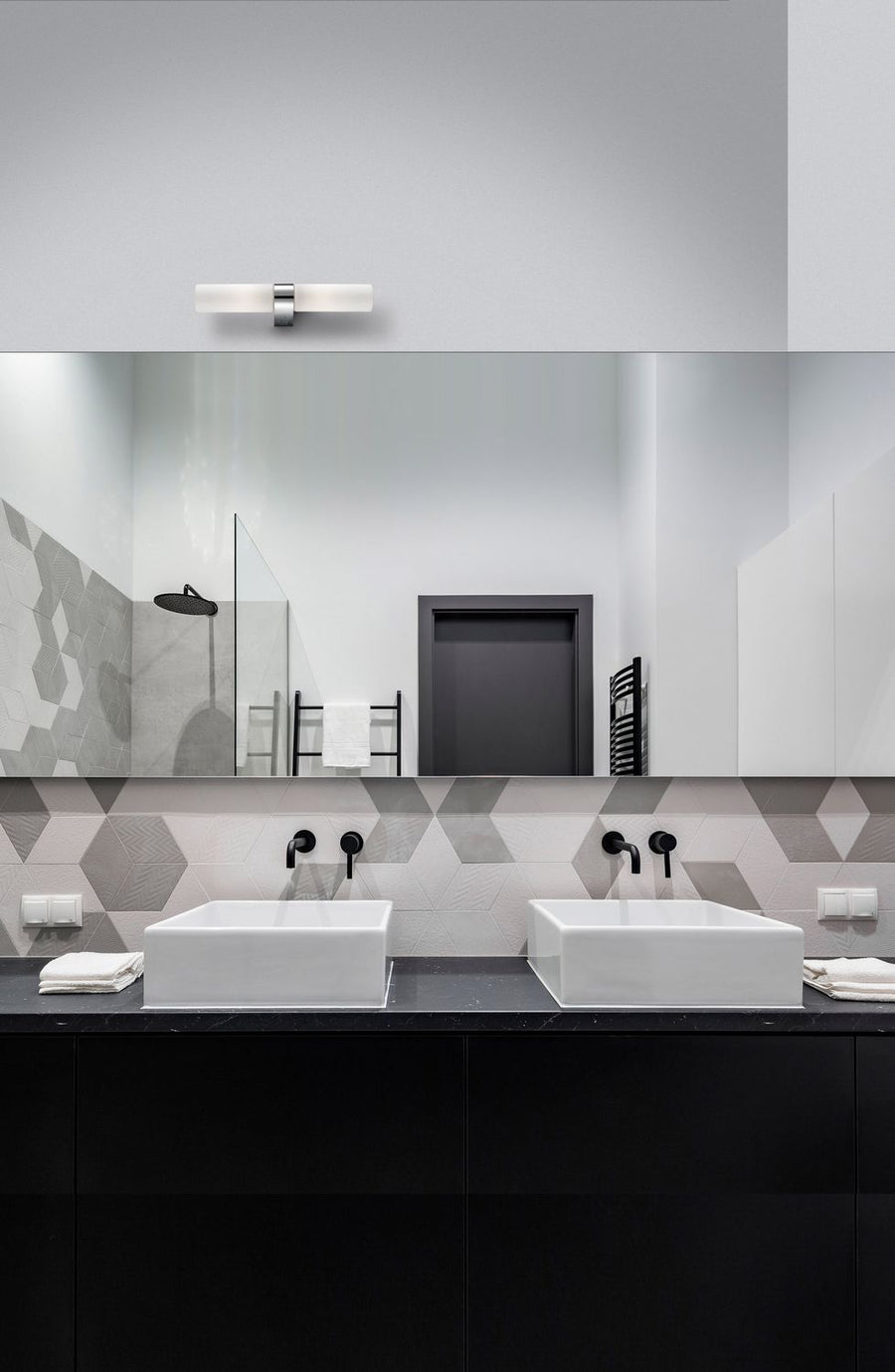 Vue rapprochée du luminaire mural allumé dans une salle de bain contemporaine