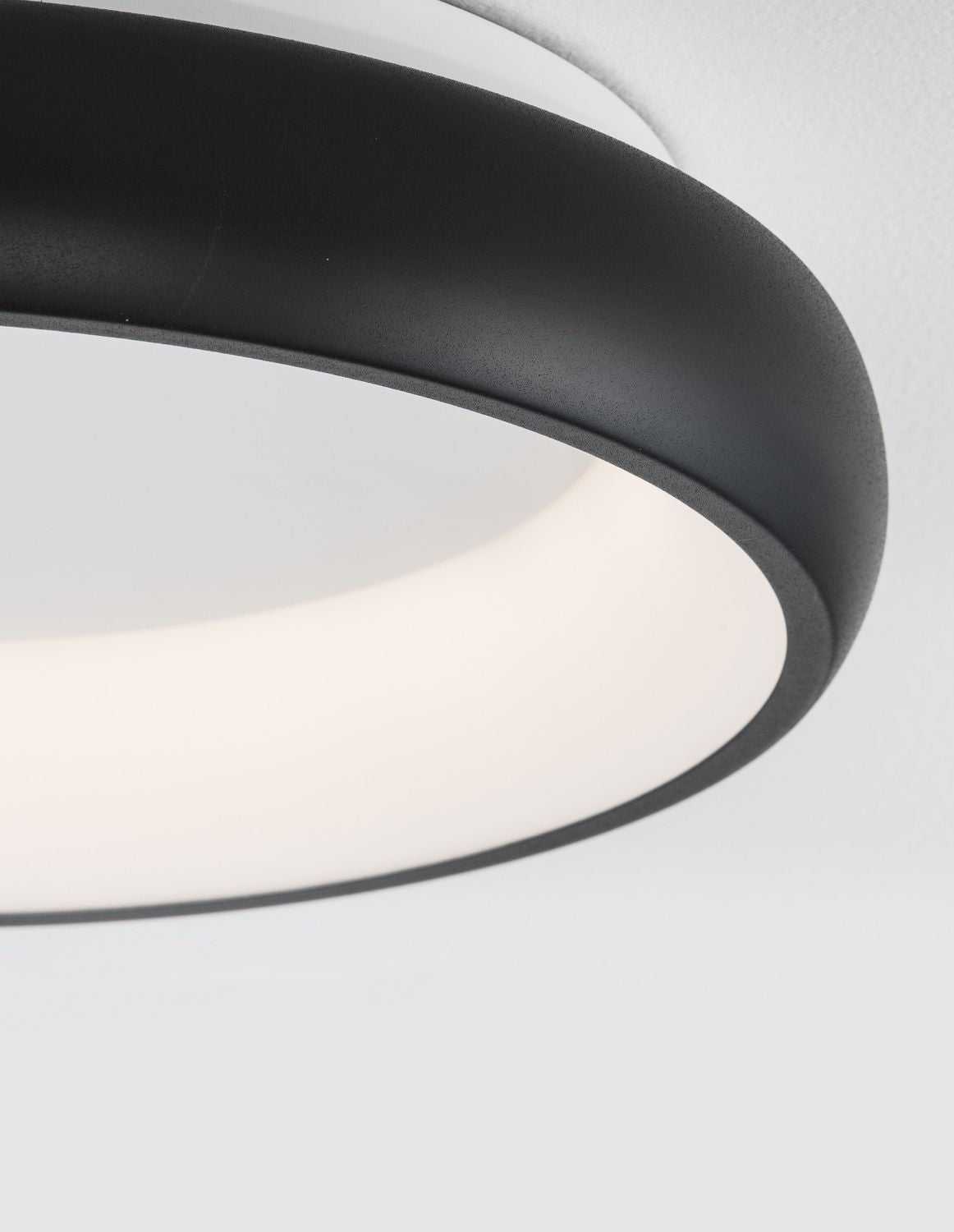 Détail rapproché du cerclage noir mat et du diffuseur opalin blanc