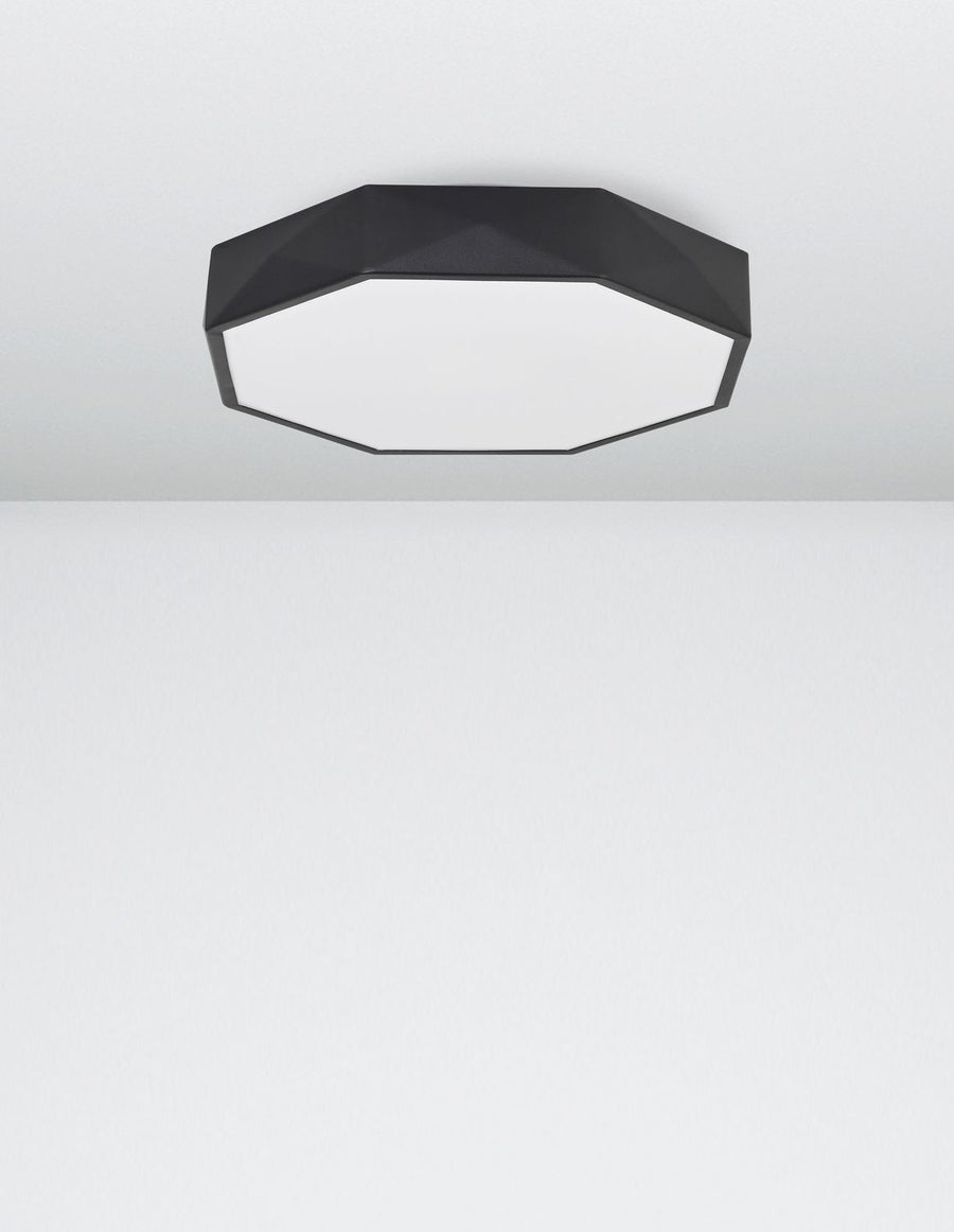 Plafonnier noir fixé au plafond blanc, vu de dessous en situation