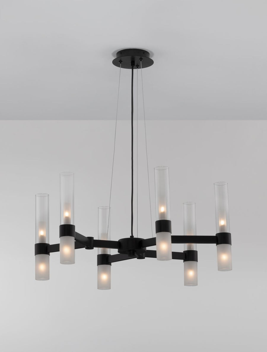 Luminaire suspendu allumé avec ampoules visibles à travers les cylindres en verre.
