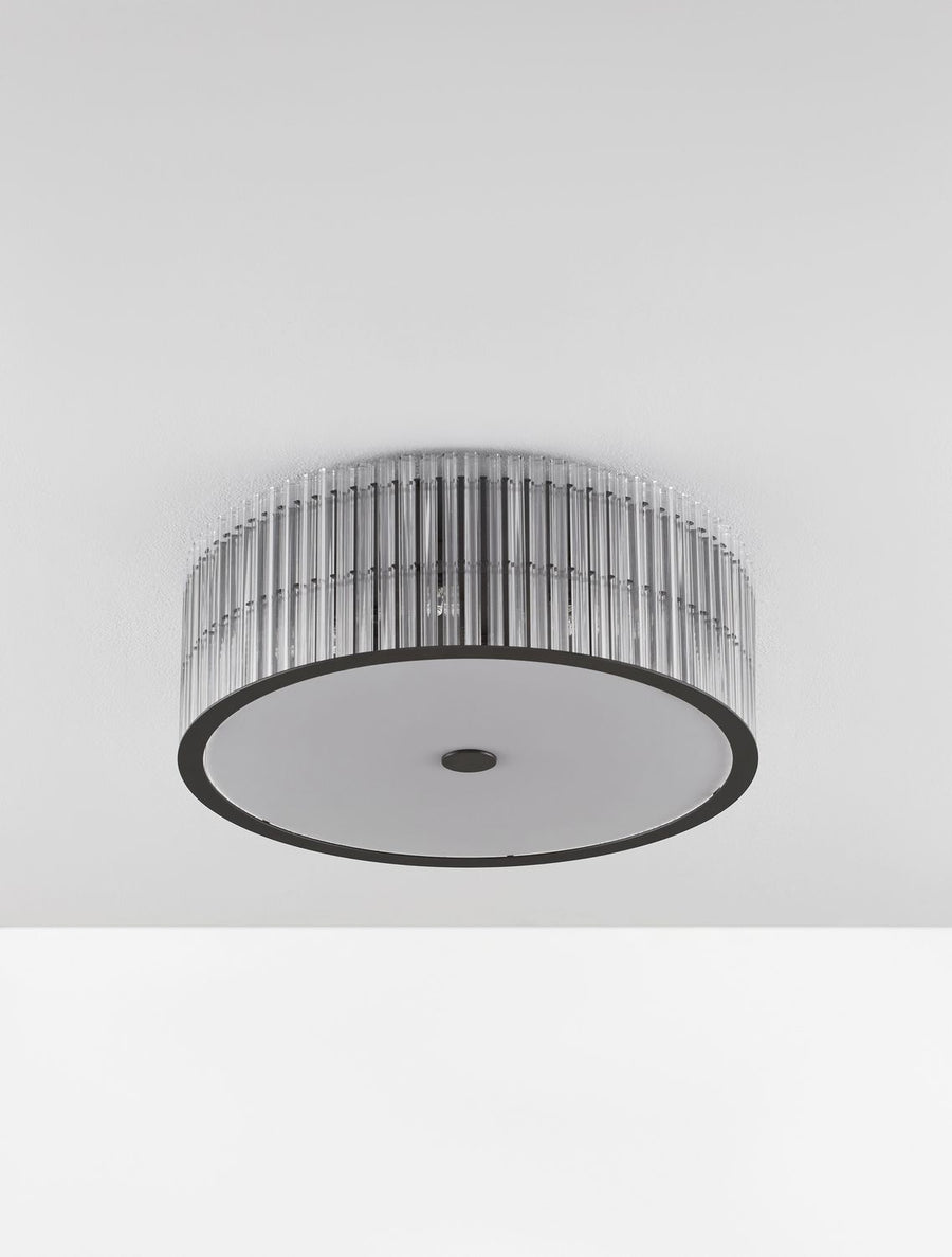 Vue de dessous du luminaire fixé au plafond, diffuseur blanc et cerclage noir.
