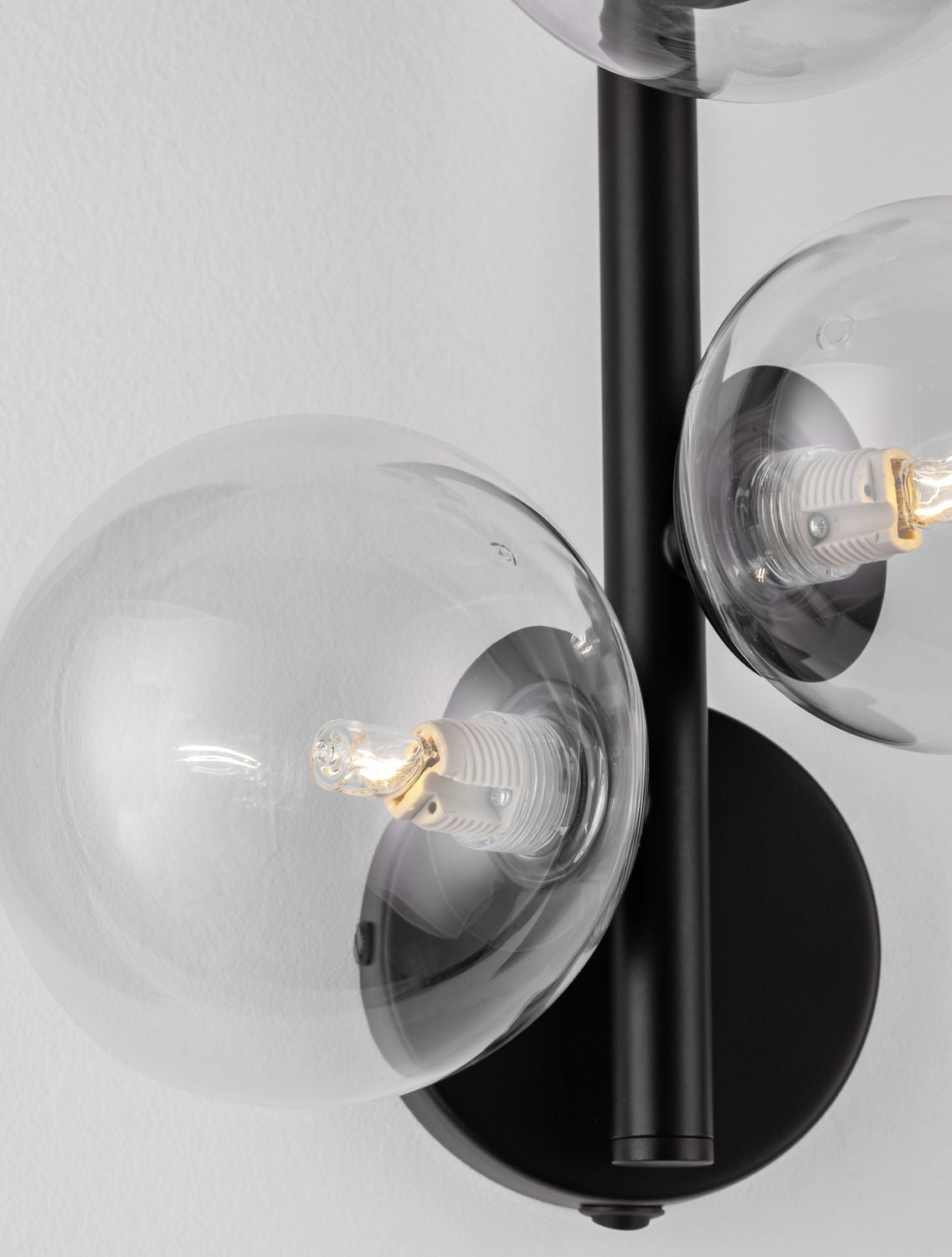 Gros plan sur une sphère de verre et l'ampoule à filament allumée.
