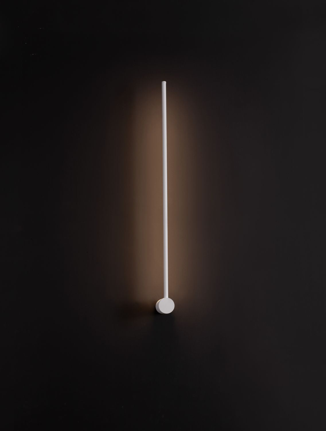 Luminaire allumé dans l'obscurité, halo lumineux diffus projeté sur le mur