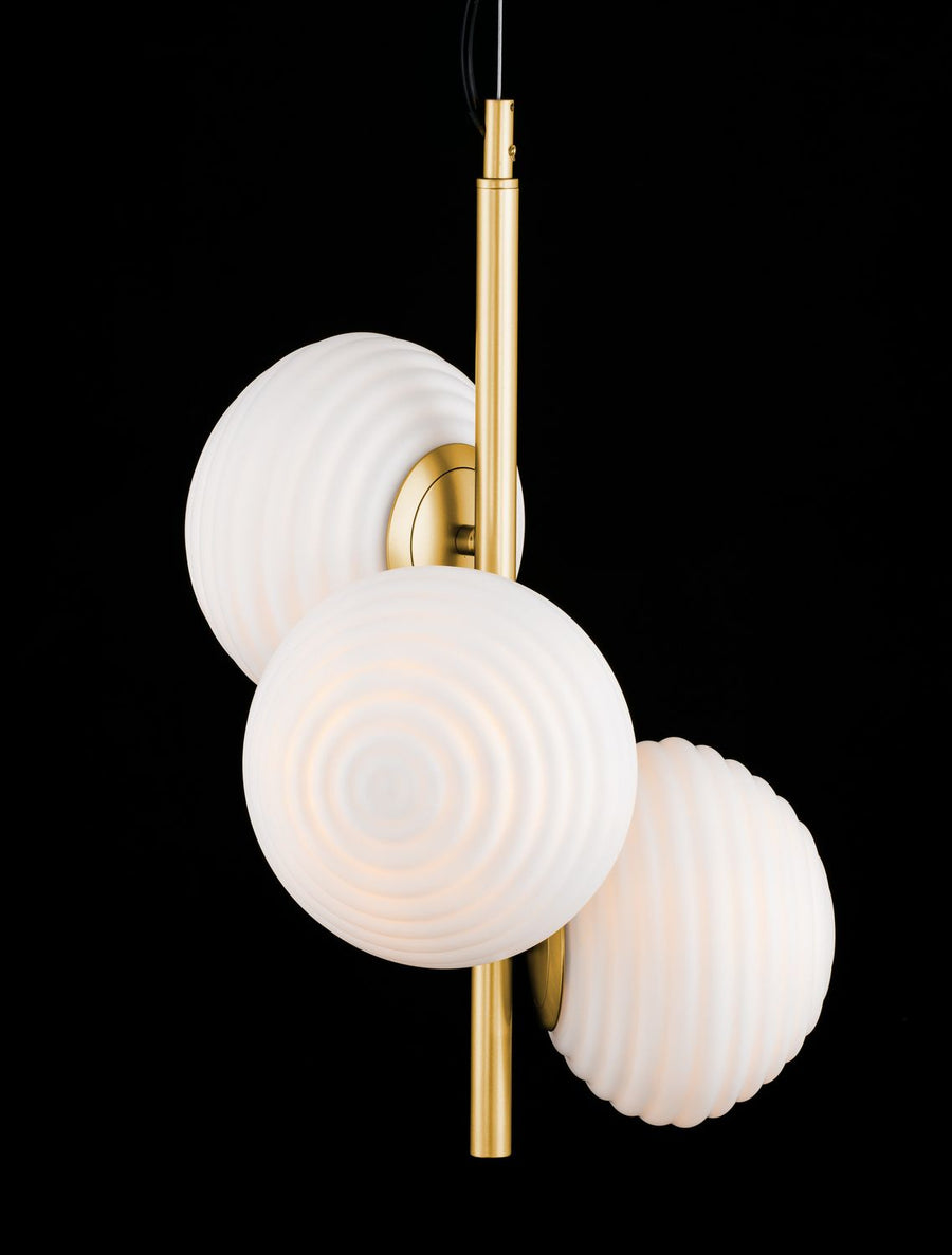 Détail rapproché du luminaire allumé sur fond noir, verre opalin lumineux