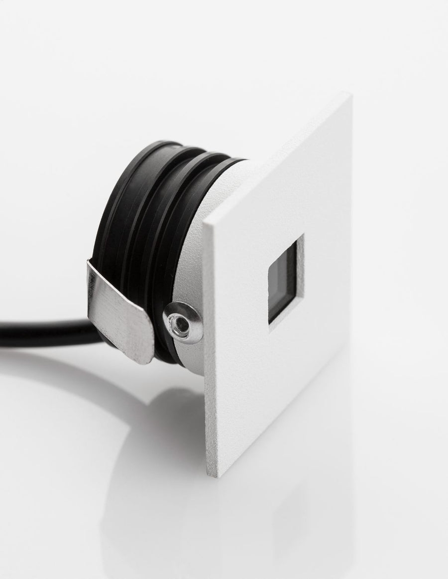 Profil du luminaire avec câble noir sortant et patte de fixation métallique