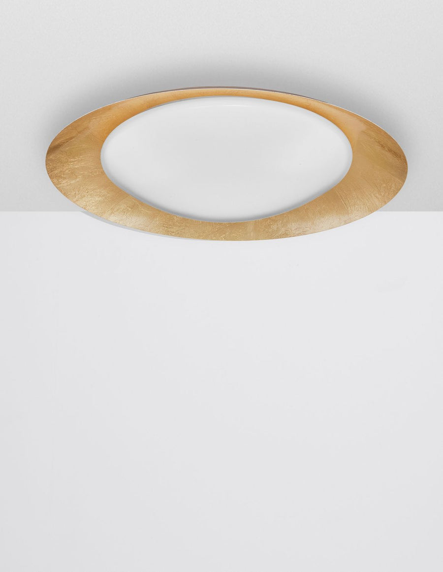 Vue frontale du plafonnier allumé, halo lumineux diffusé sous le plafond blanc