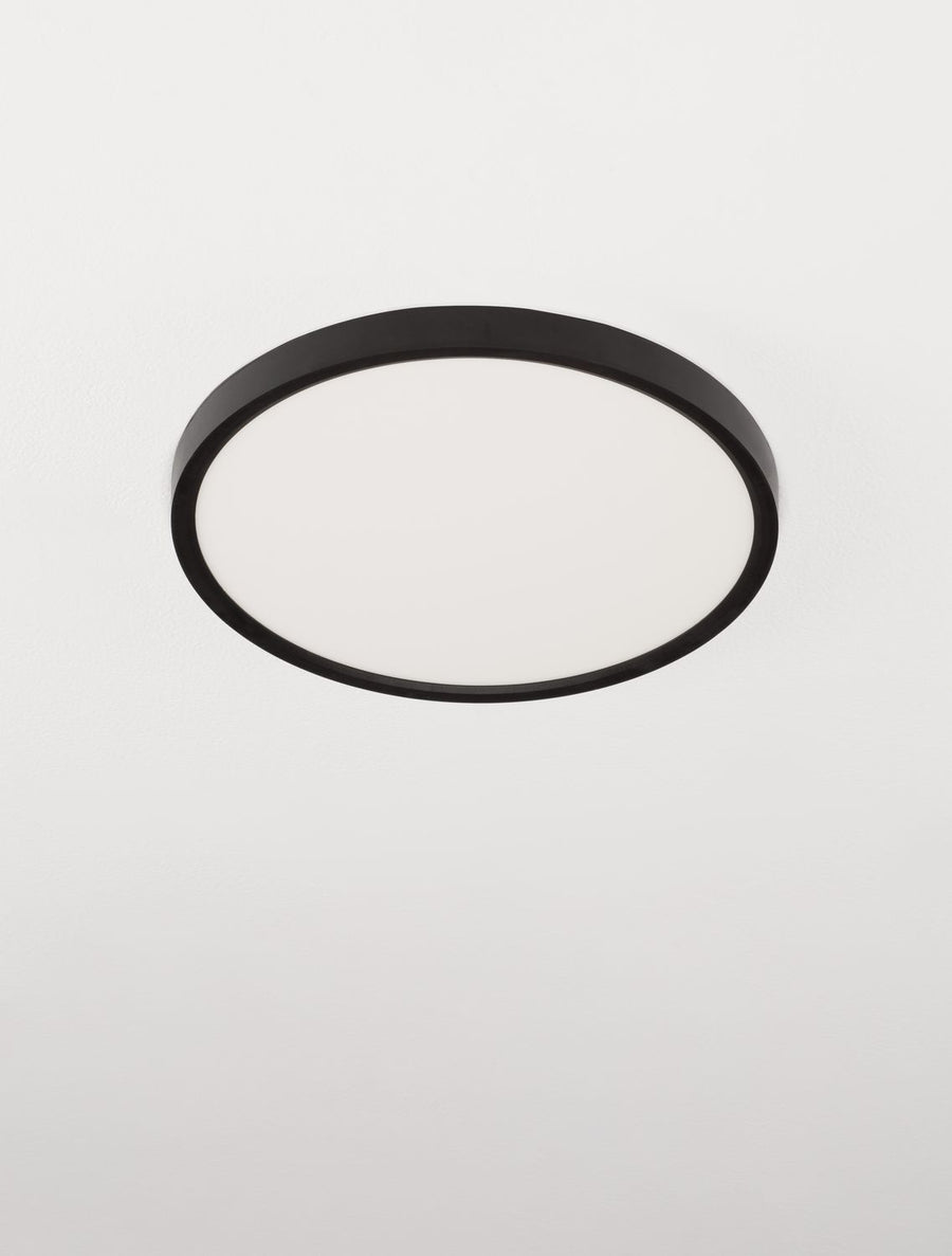 Vue presque frontale du luminaire rond, cerclage noir fin et vasque blanche.