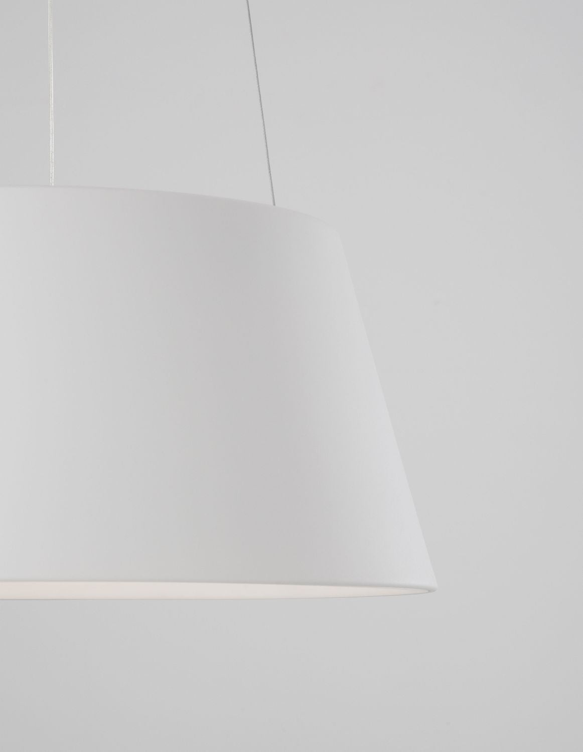 Gros plan sur le côté de l'abat-jour blanc et un câble de suspension.