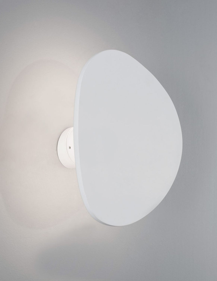 Détail de profil d'un diffuseur allumé projetant une lumière douce sur le mur