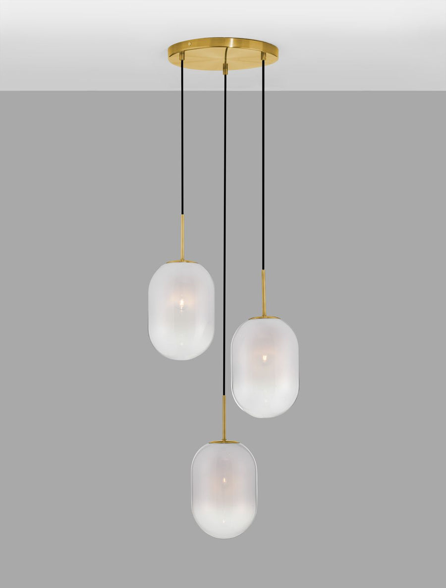 Suspension allumée sur fond gris, diffusant une lumière chaude à travers le verre dépoli