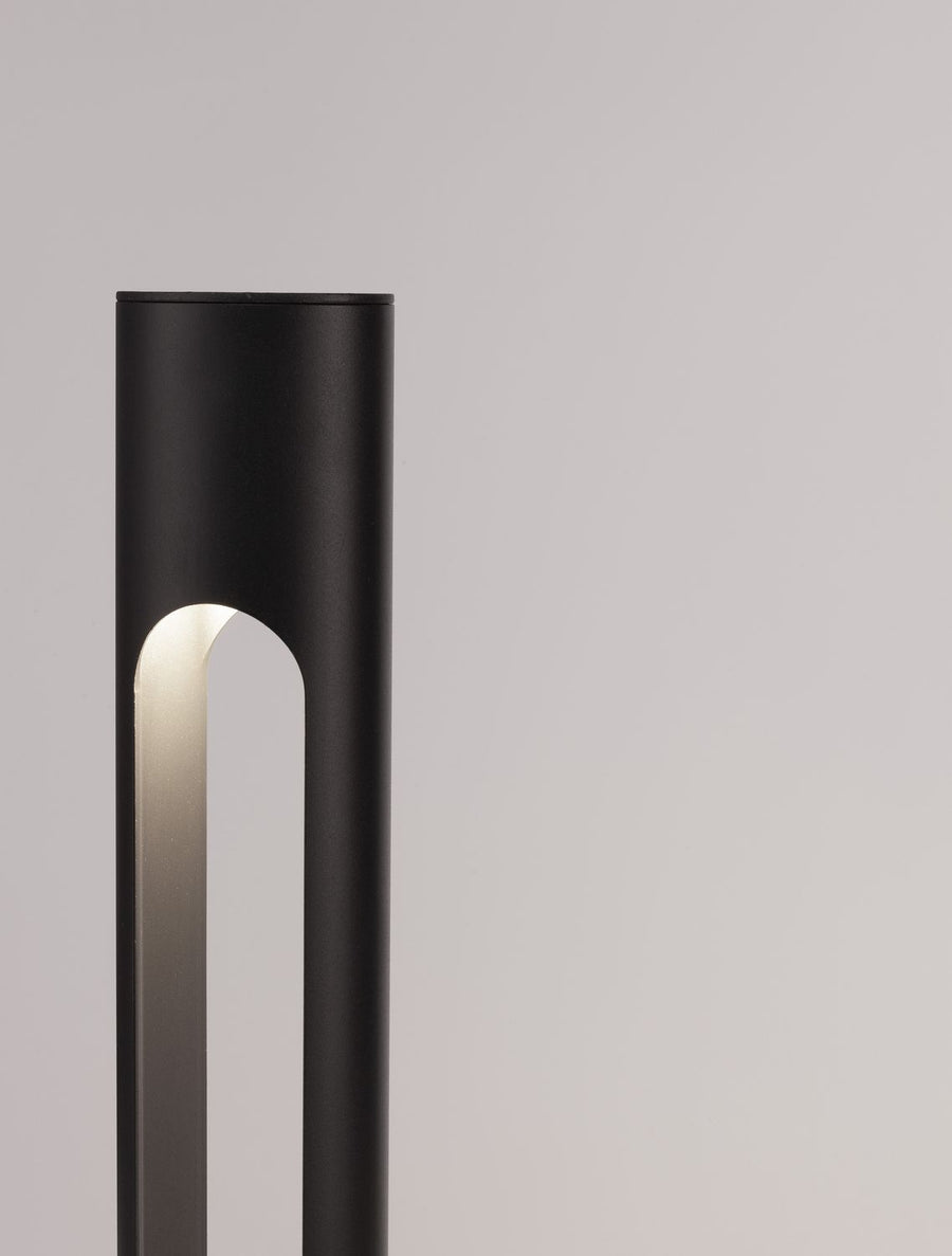 Détail du haut de la borne avec lumière chaude dans la fente verticale.