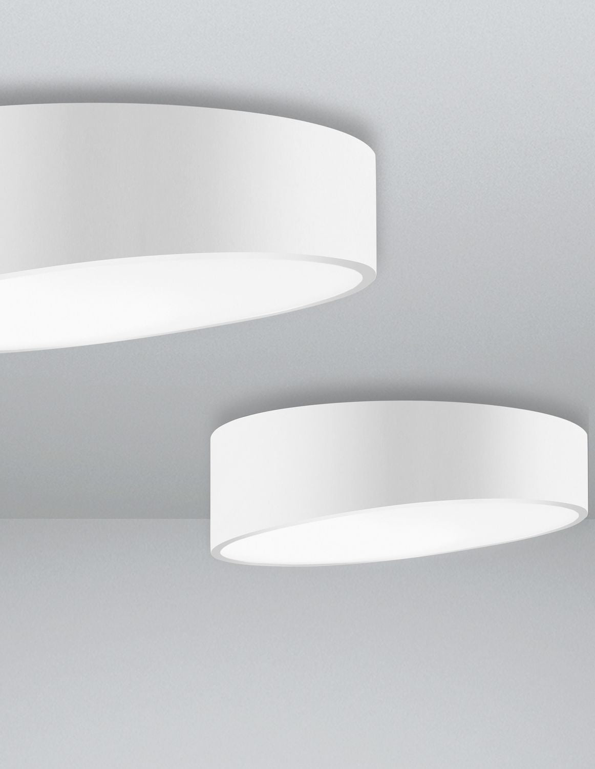 Deux plafonniers blancs de tailles différentes posés au plafond