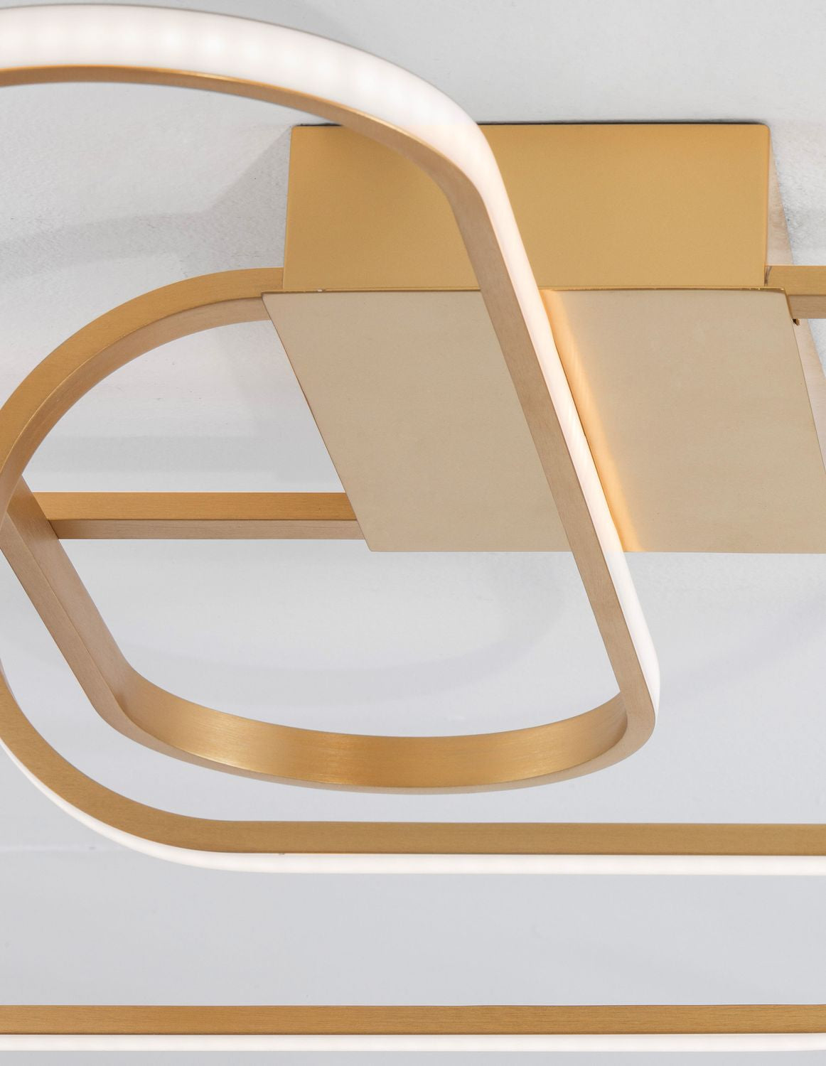 Vue rapprochée du luminaire montrant la finition dorée et le diffuseur blanc