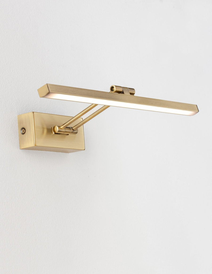 Même applique allumée, diffusant une lumière chaude sur le mur blanc