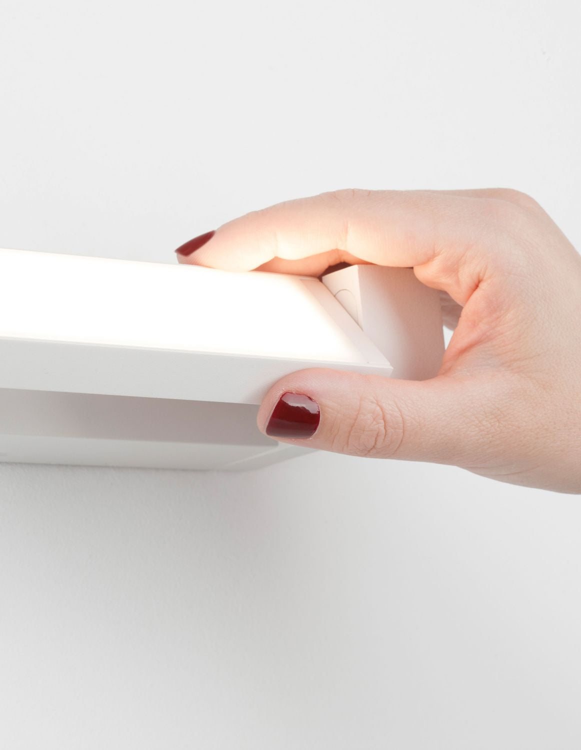 Main aux ongles vernis touchant le bord du diffuseur en détail