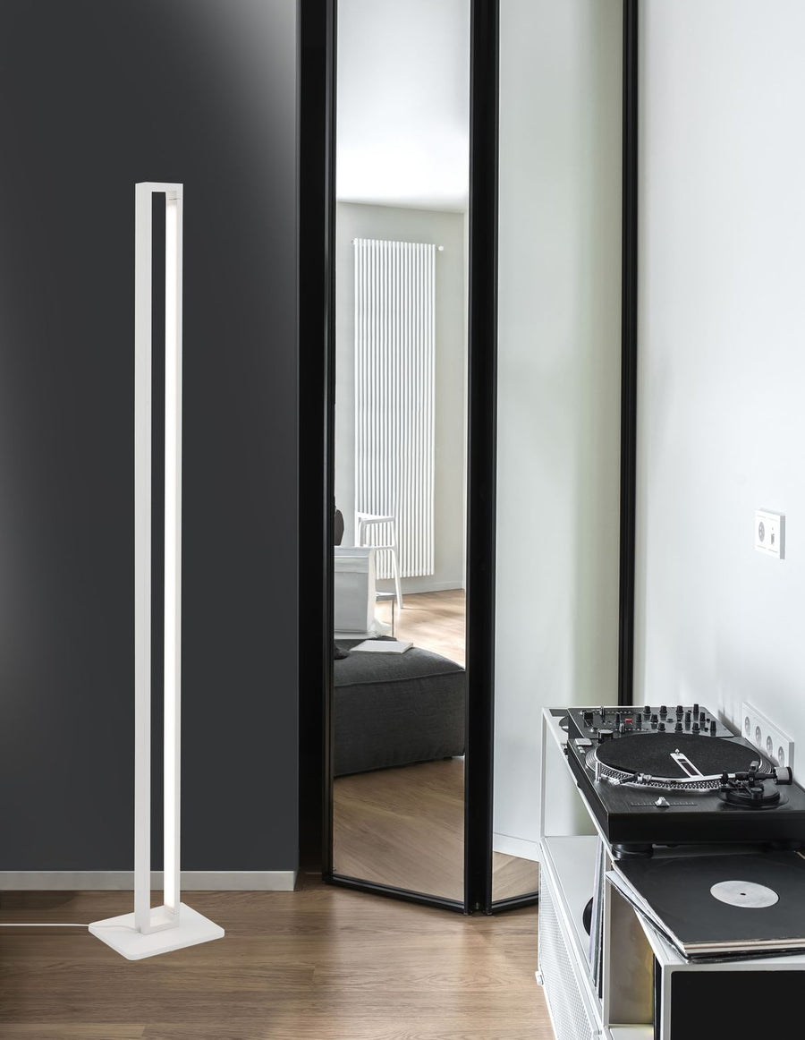 Lampadaire blanc vertical installé près d'un miroir, avec platine vinyle à droite