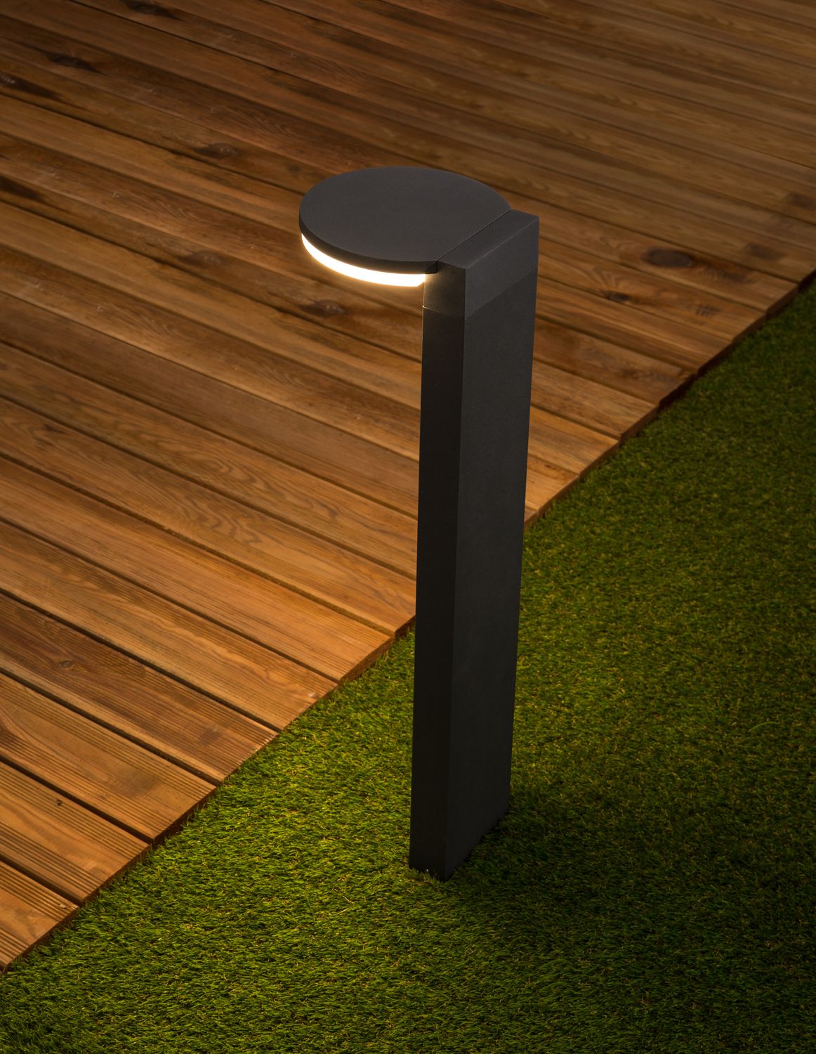 Mise en ambiance nocturne sur terrasse en bois, halo lumineux au sol