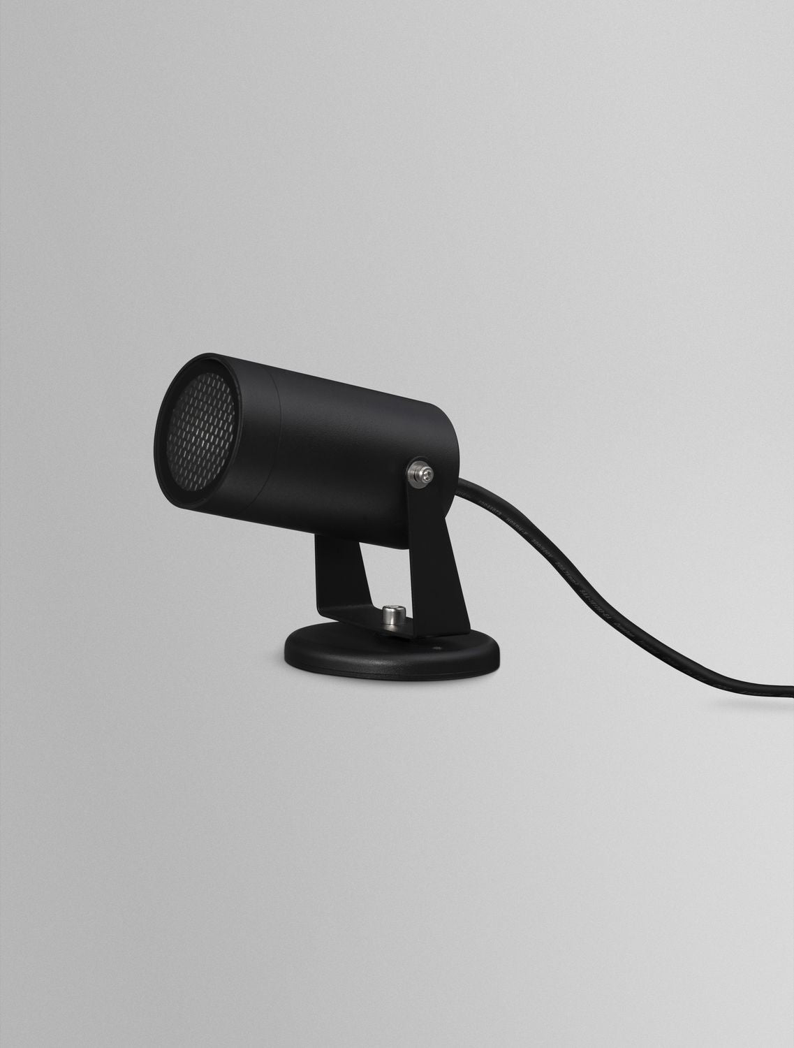 Projecteur noir vu de biais avec son câble d'alimentation apparent