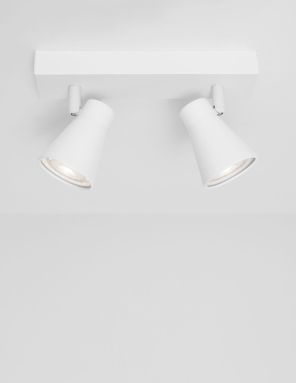 Vue plongeante du plafonnier blanc et de ses deux spots inclinables.