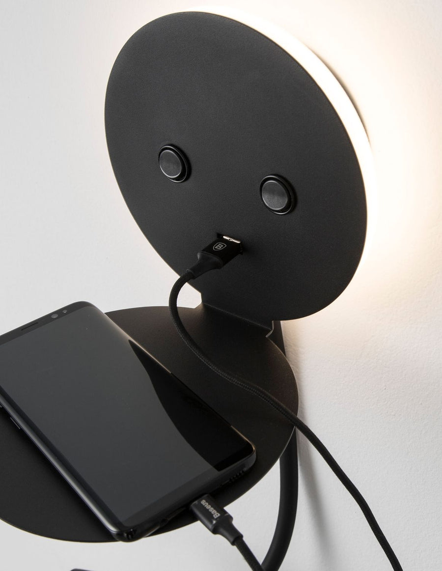 Détail d'usage, smartphone en charge posé sur la petite tablette intégrée