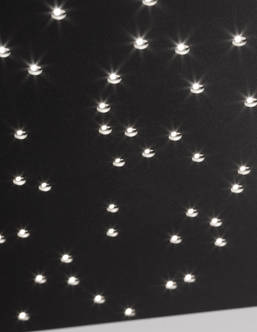 Détail rapproché des LED allumées dessinant une voûte étoilée sur fond noir.