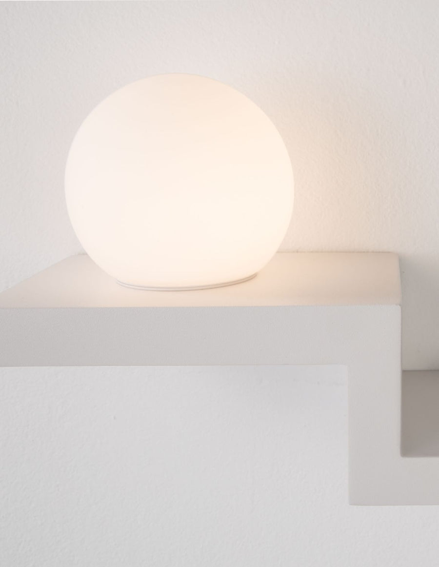 Gros plan du globe lumineux allumé diffusant une lumière chaude sur le mur