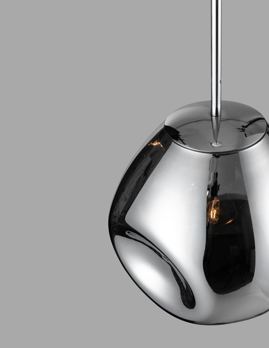 Vue rapprochée de la suspension chromée montrant le verre brillant et ampoule.
