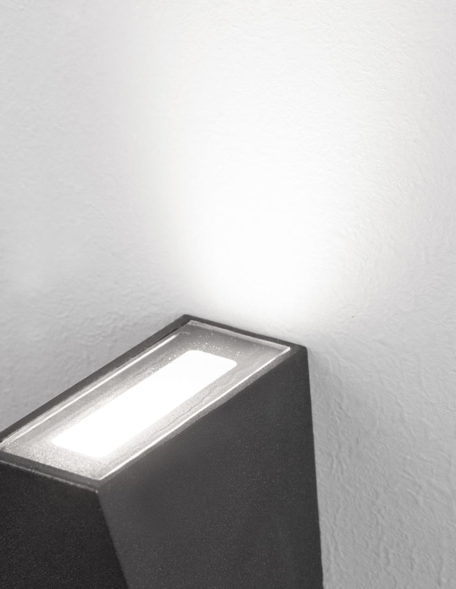 Vue en contre-plongée du luminaire noir projetant sa lumière vers le haut