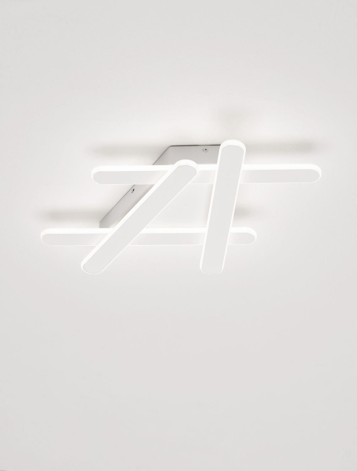 Plafonnier blanc allumé au plafond, lumière diffuse et ombres douces