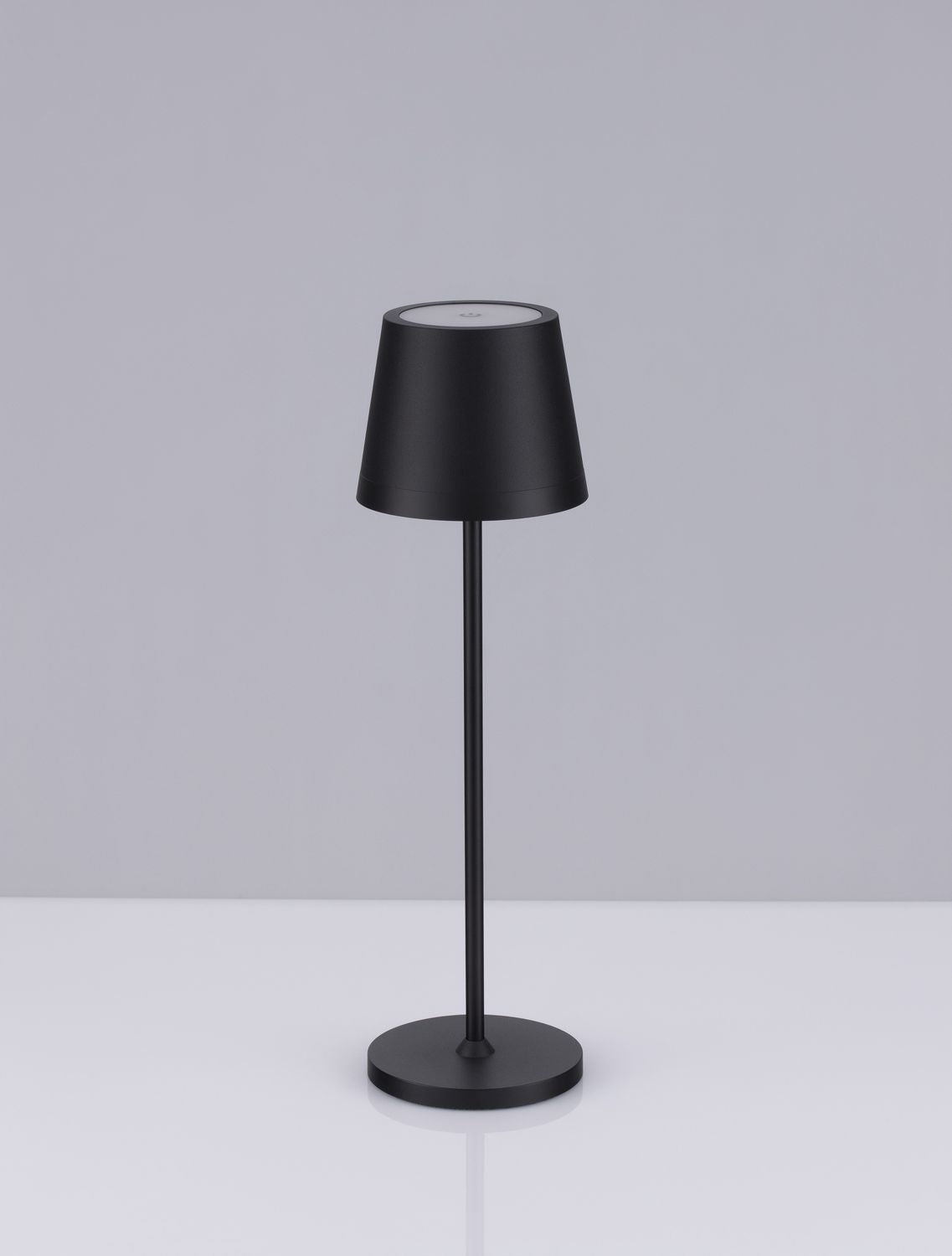 Vue de face sur fond gris, lampe noire élancée avec abat-jour conique et base ronde.