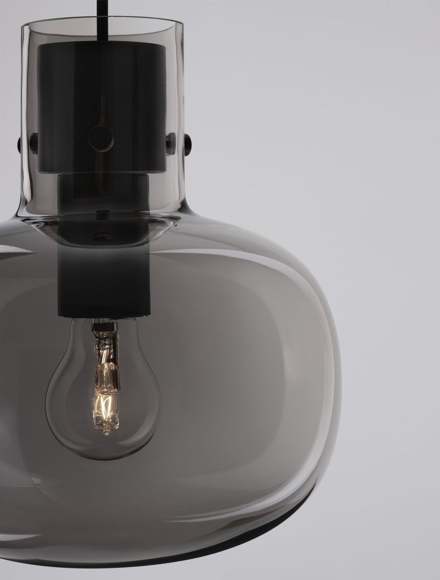Zoom sur la douille noire et l'ampoule à filament dans le verre fumé