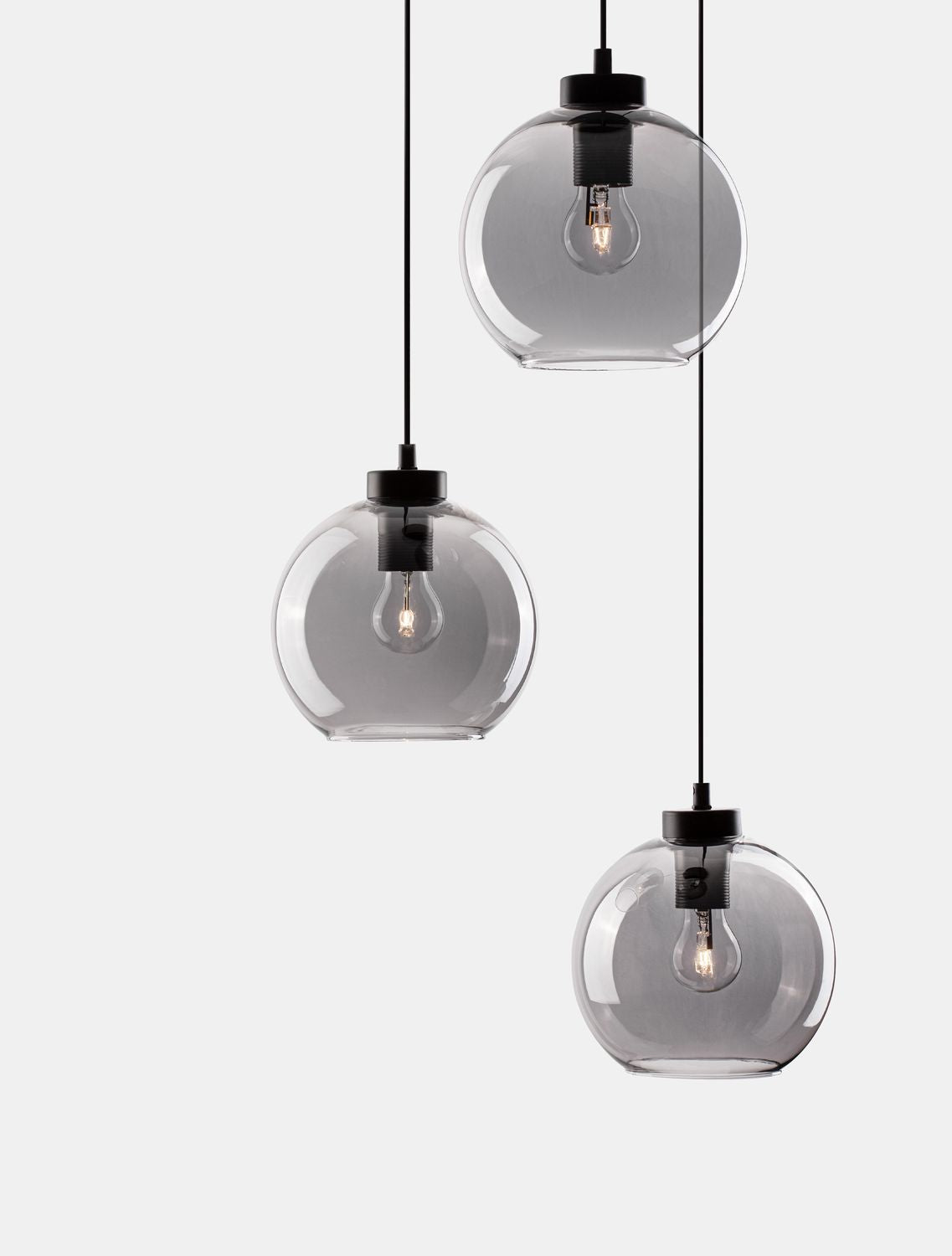 Gros plan sur les globes en verre fumé et les douilles noires, ampoules visibles.