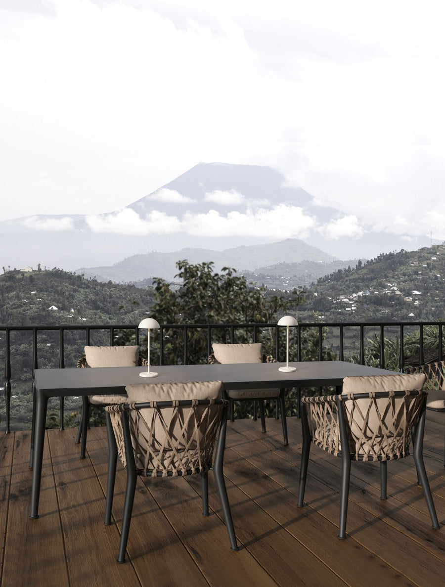Deux lampes blanches sans fil sur une table de terrasse avec vue montagne