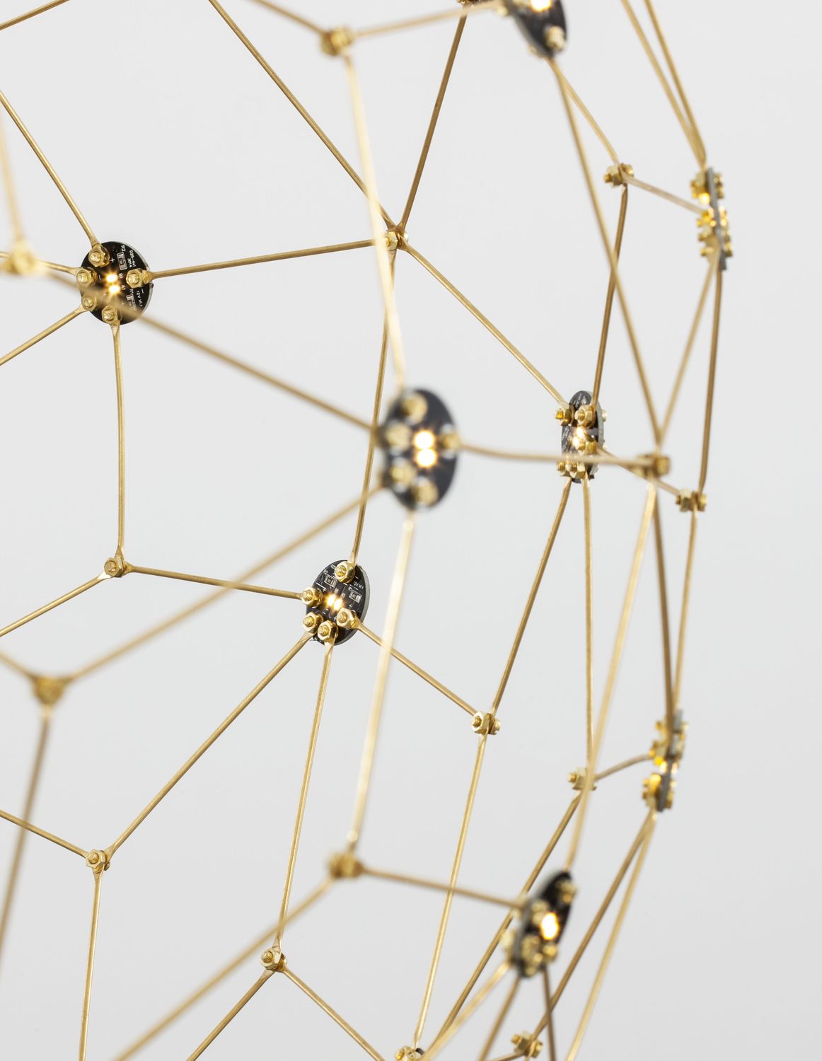 Détail macro des modules LED noirs et tiges dorées assemblées en étoile
