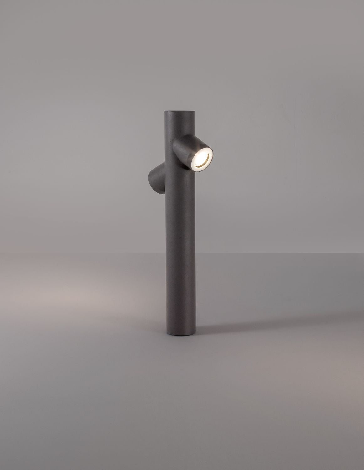 Borne allumée diffusant une lumière chaude sur fond gris dégradé