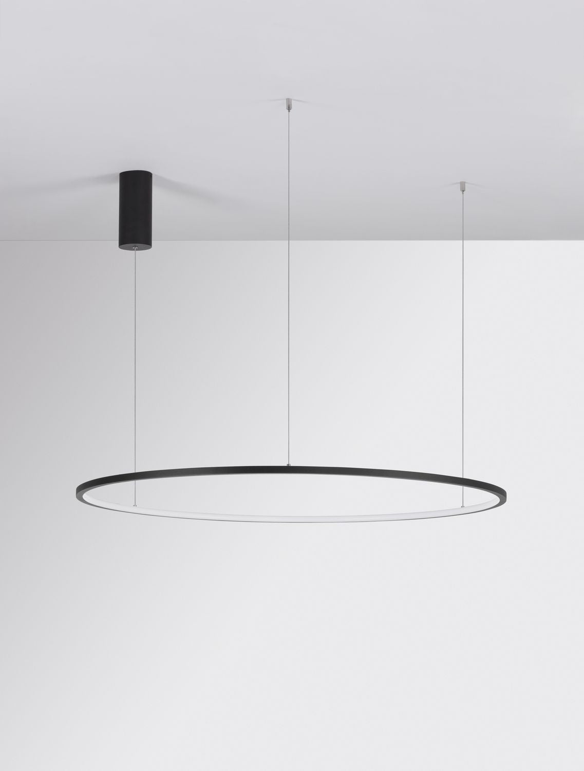 Luminaire suspendu sous plafond blanc, longs câbles fins bien visibles