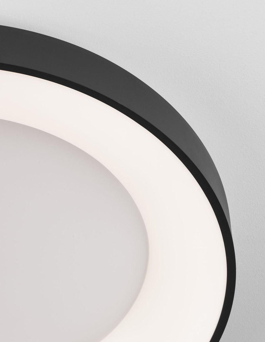 Gros plan sur le cerceau noir et l'anneau lumineux contre le plafond