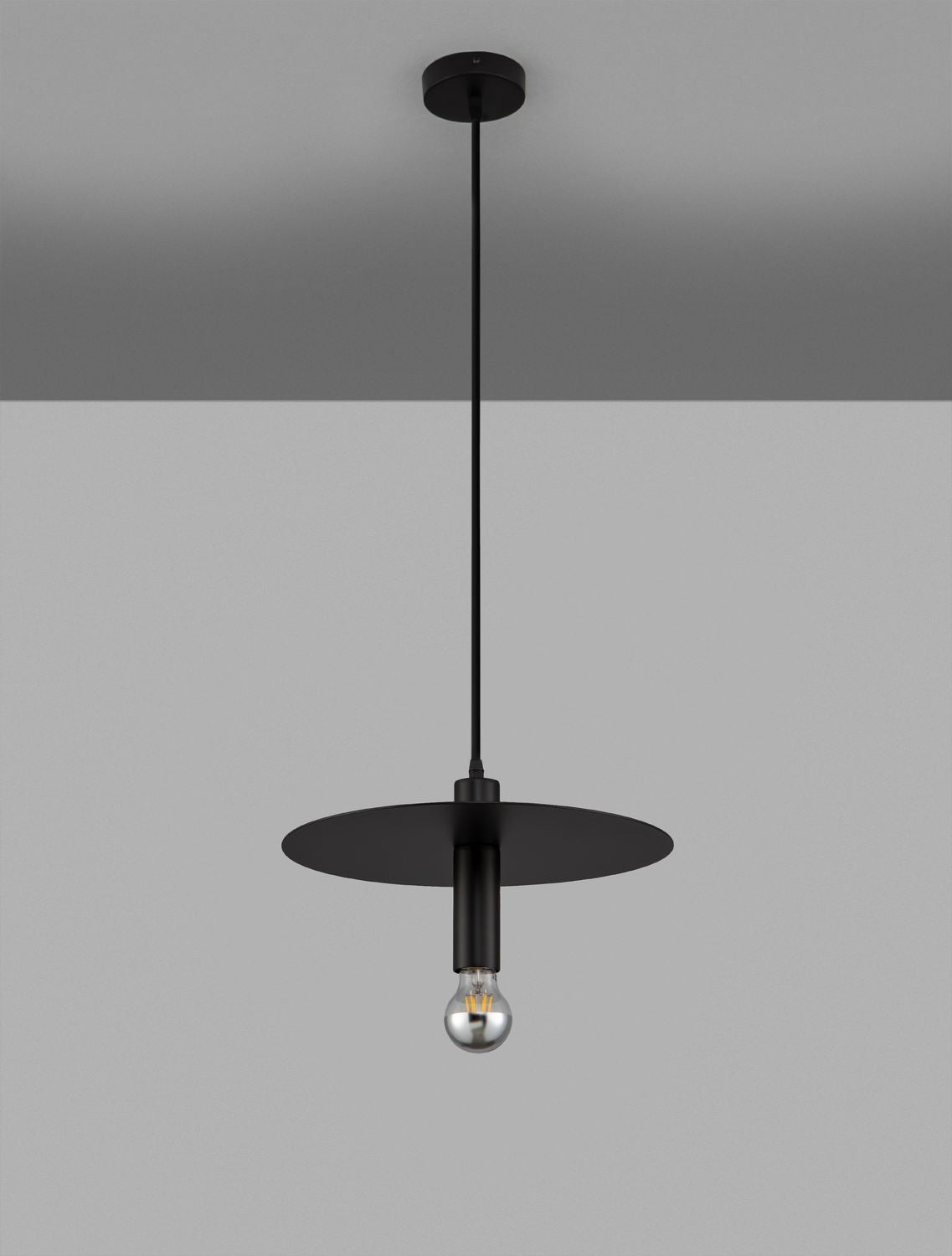 Produit entier suspendu devant un mur gris, disque et ampoule visibles