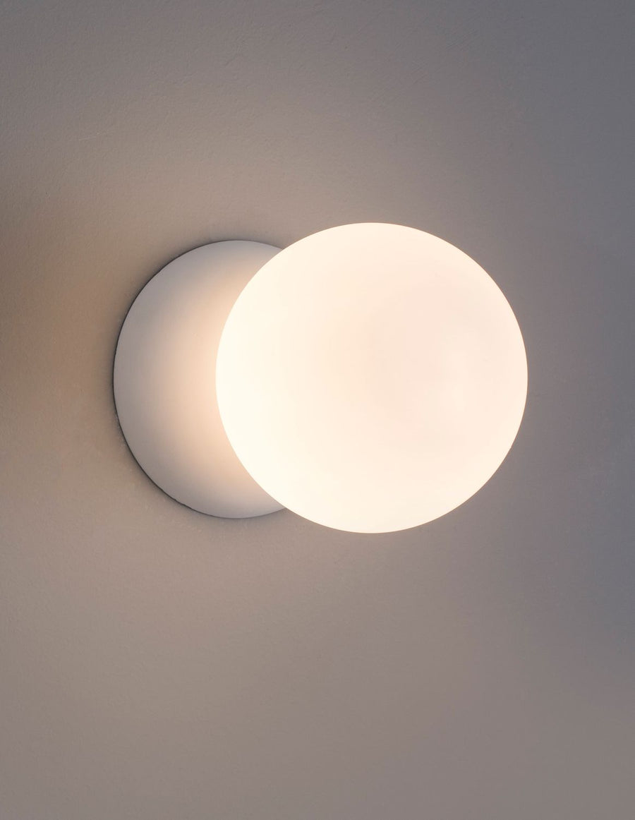 Applique murale allumée fixée au mur, globe lumineux décalé sur sa base