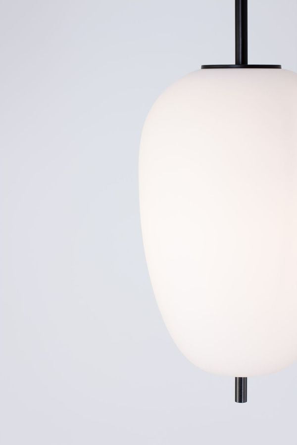 Détail de la fixation noire et du haut du diffuseur en verre opalin.