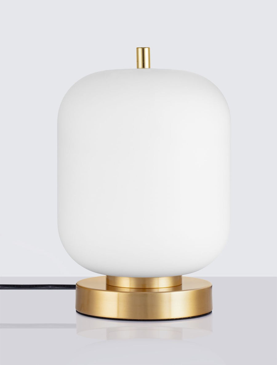 Vue de face, lampe éteinte, abat-jour en verre blanc et base en laiton