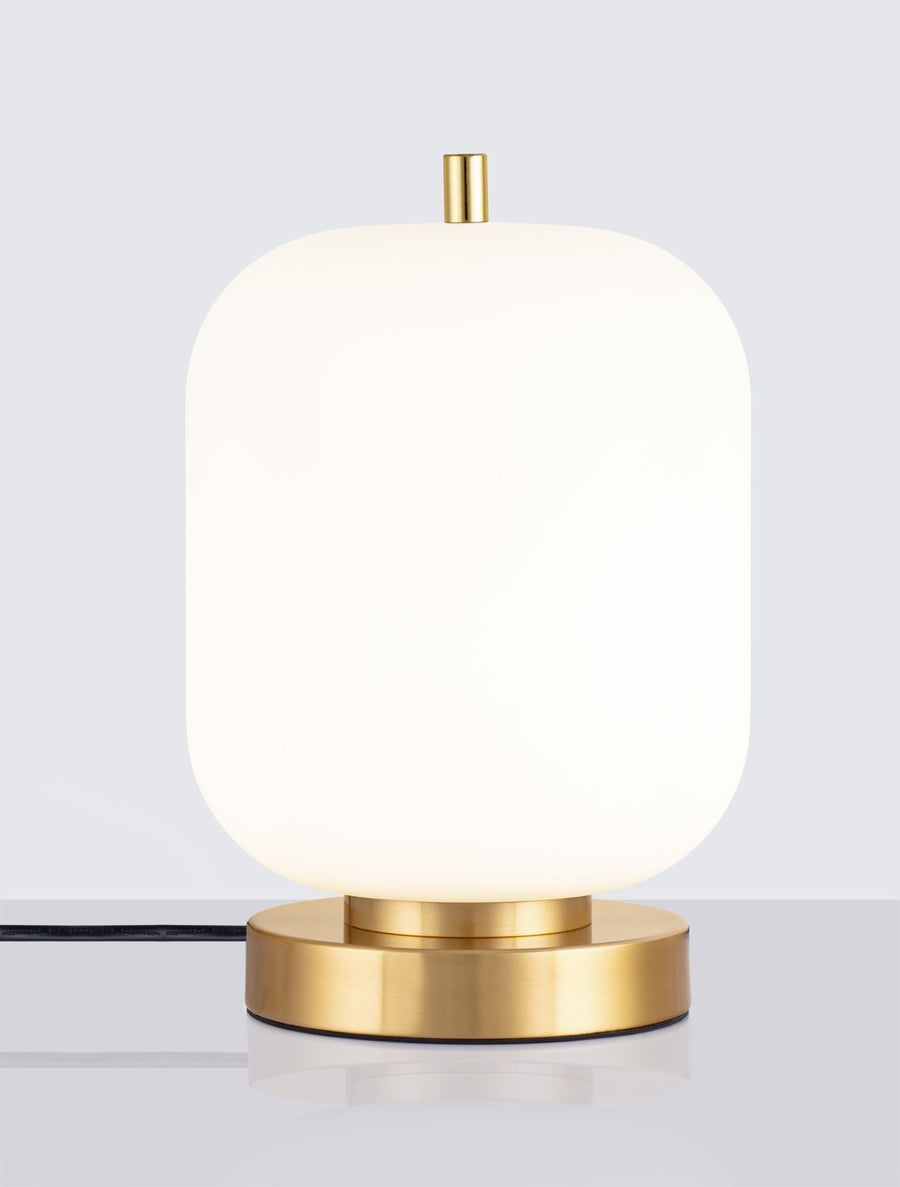 Lampe allumée sur fond gris clair, diffusant une lumière chaude et douce