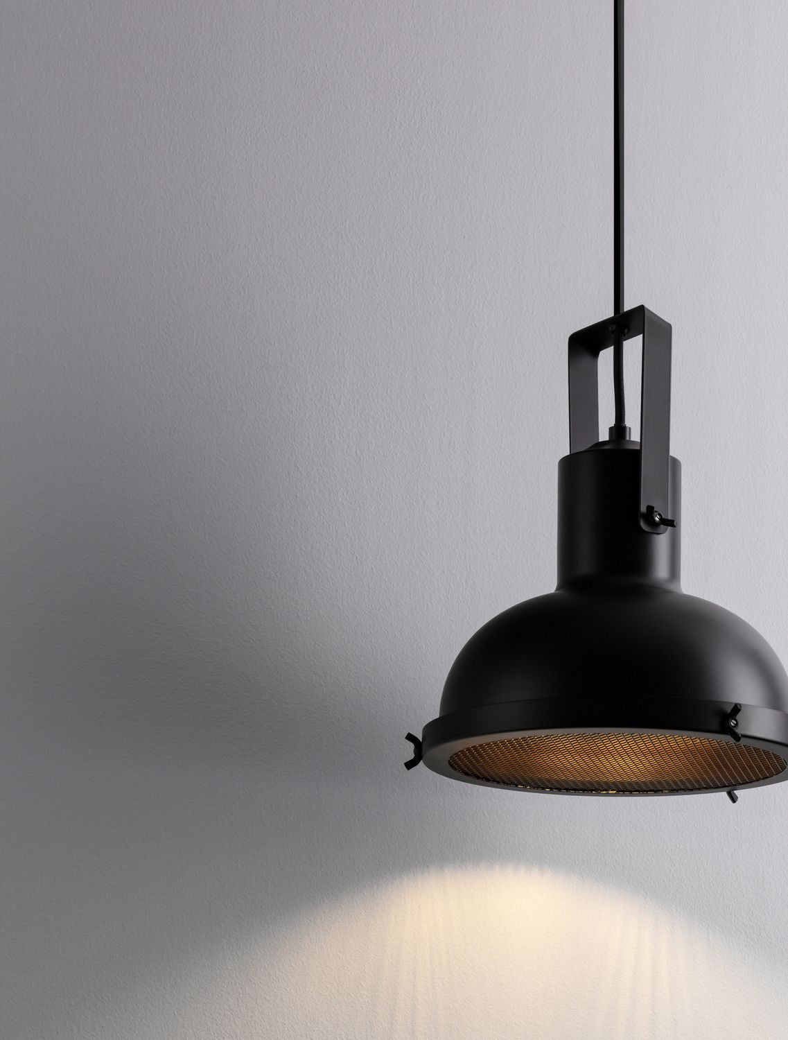 Détail rapproché de la grille métallique et du halo lumineux chaud