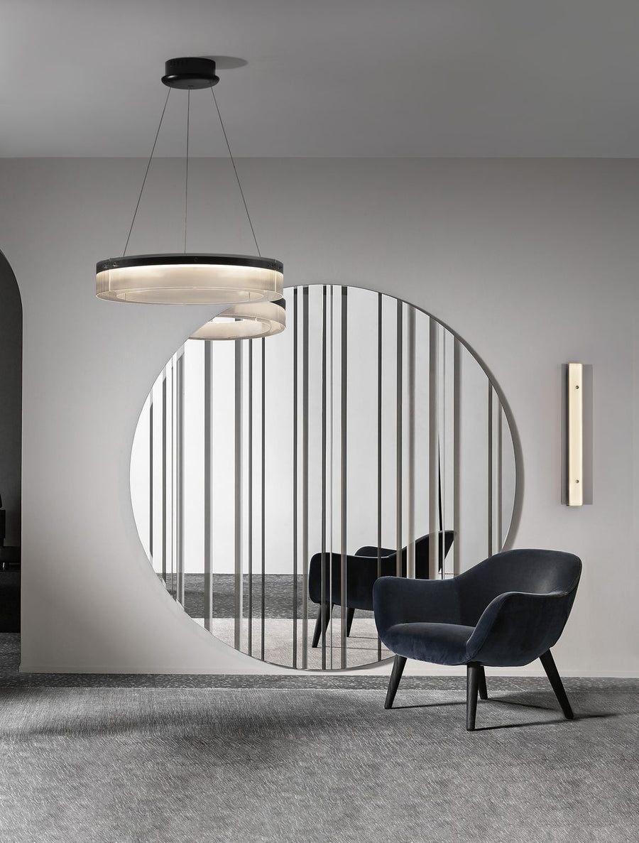 Suspension anneau allumée au-dessus d'un fauteuil bleu dans un intérieur contemporain