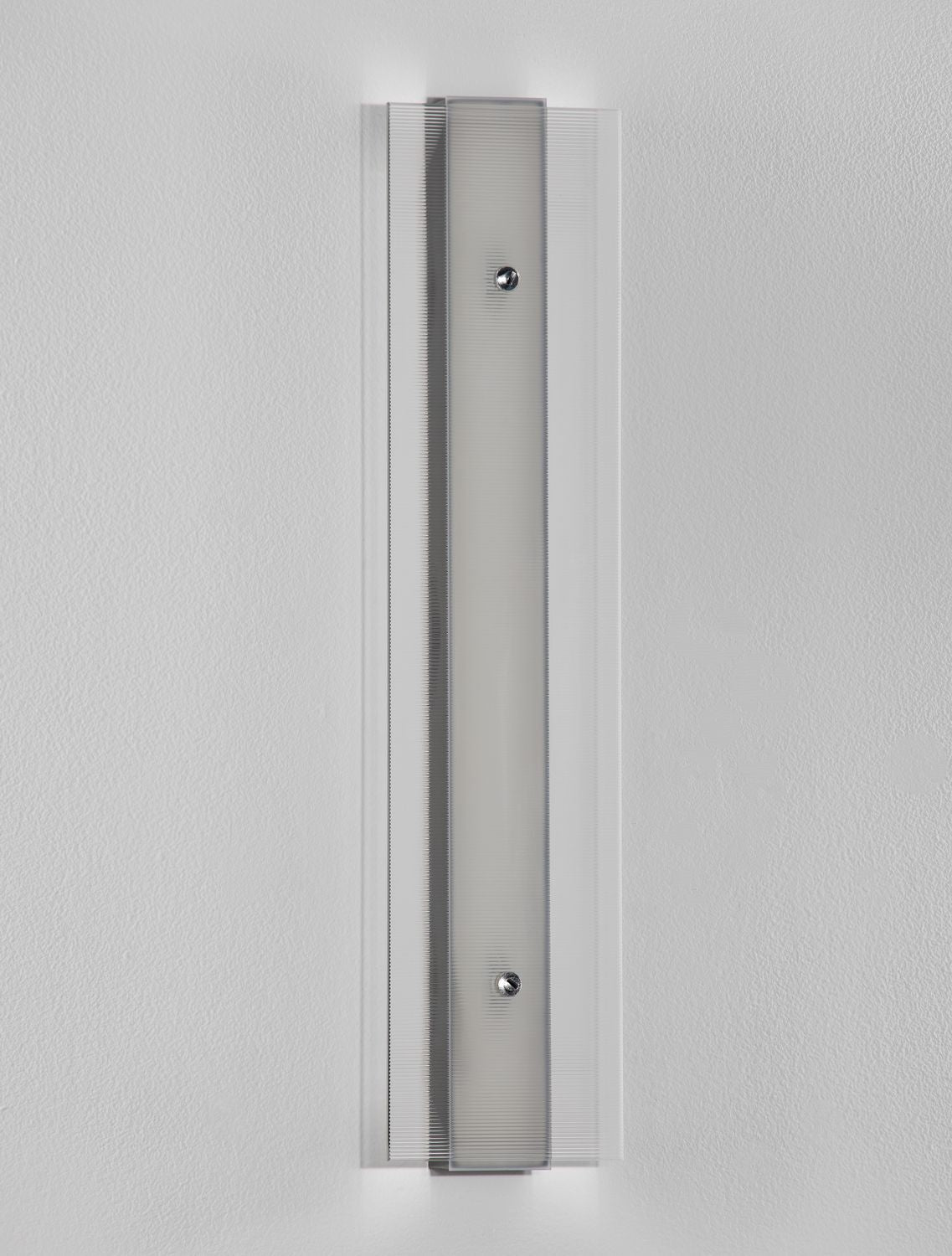 Détail de la face avant montrant le verre strié et les deux vis de fixation.